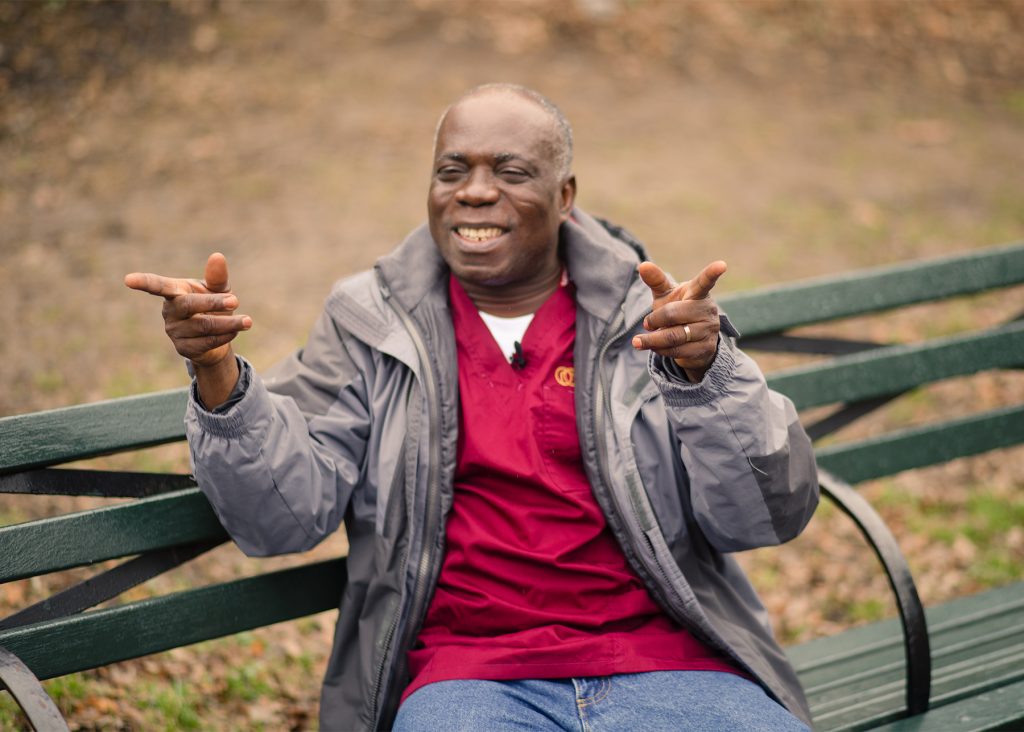 home caregiver joking sitting in a park bench
